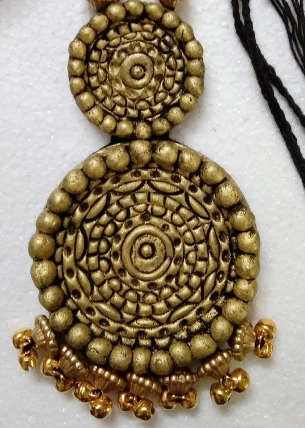 Body jewelry,Yellow,Religious item,Art,Circle,Jewellery,Badge,Metal,Close-up,Font