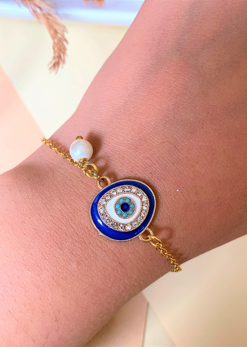 Get Studded Blue Evil Eye Gold Plated Bracelet With Pearl Drop at ₹ 499